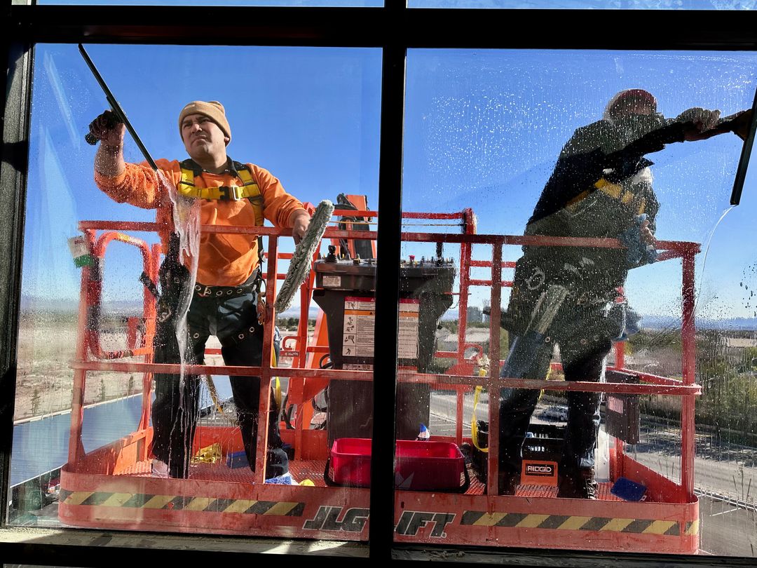 a man in orange jacket cleaning a window